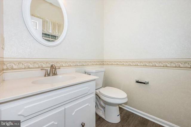 bathroom with hardwood / wood-style flooring, vanity, and toilet