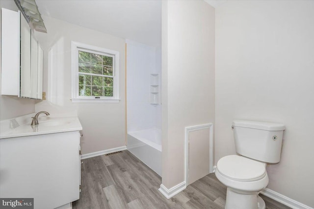 full bathroom with hardwood / wood-style flooring, vanity, shower / bathtub combination, and toilet