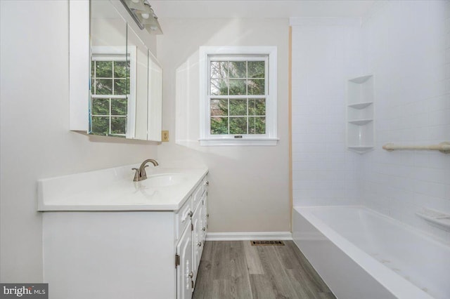 bathroom featuring hardwood / wood-style floors, vanity, plenty of natural light, and tub / shower combination