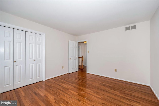 unfurnished bedroom featuring wood-type flooring and a closet