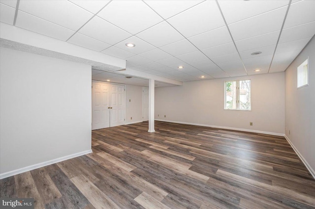 basement featuring dark hardwood / wood-style floors and a drop ceiling