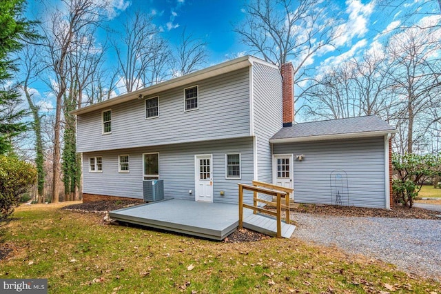 back of house with central air condition unit, a wooden deck, and a yard