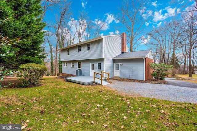 rear view of house featuring central AC unit, a yard, and a wooden deck