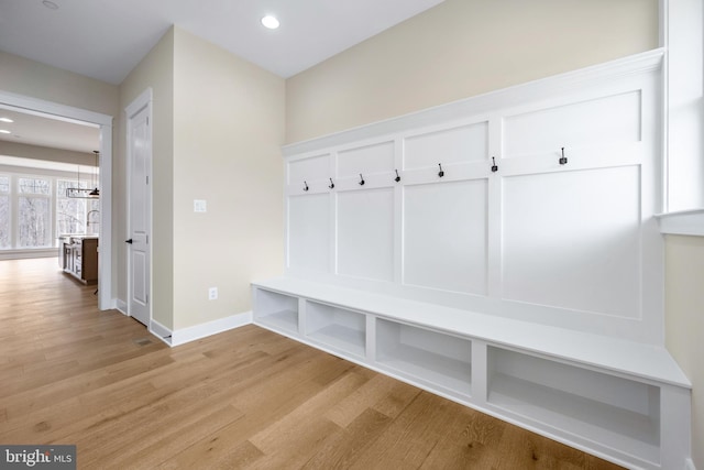 mudroom with light wood-type flooring and a chandelier