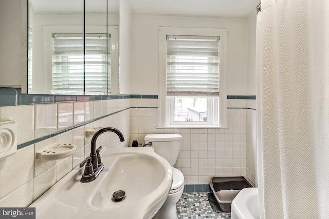 bathroom with tile walls, sink, toilet, and tile patterned flooring