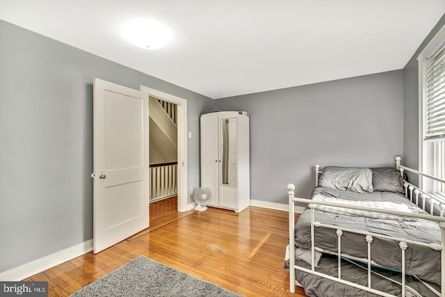 bedroom with baseboards and wood finished floors