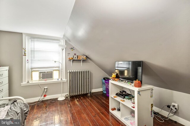 bedroom with baseboards, vaulted ceiling, and hardwood / wood-style floors