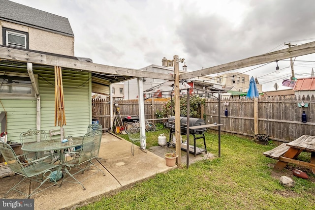 view of yard featuring outdoor dining space, fence, and a patio