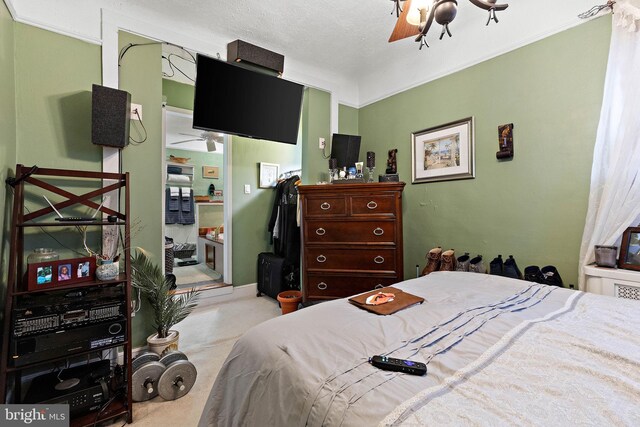 bedroom with a textured ceiling, ceiling fan, and light carpet