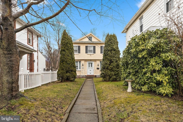 view of front of property with a front yard and fence