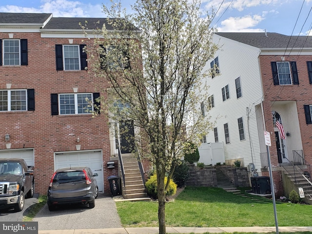 townhome / multi-family property with a front lawn and a garage