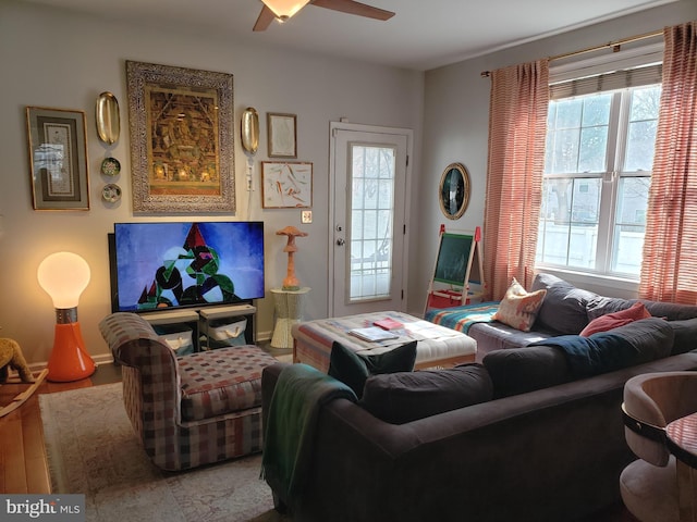 living room featuring plenty of natural light, ceiling fan, and wood-type flooring