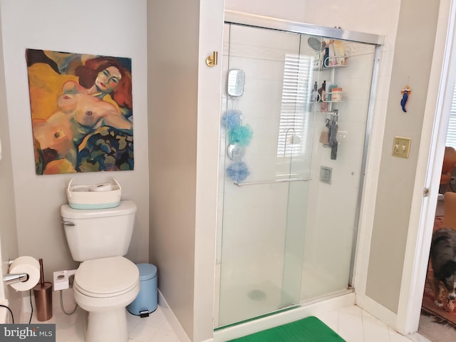 bathroom with tile patterned flooring, toilet, and a shower with shower door