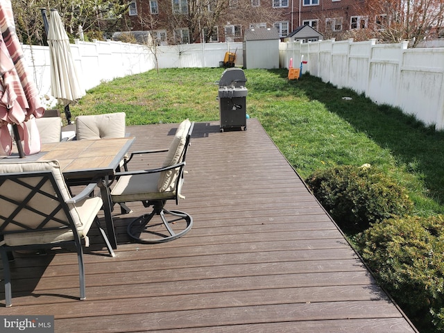 wooden deck featuring a yard and grilling area