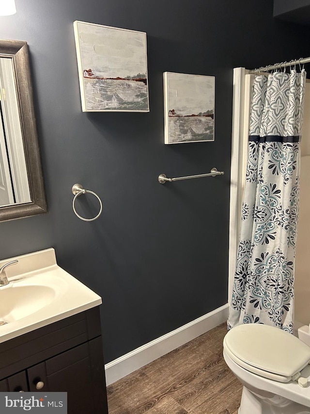 bathroom with a shower with curtain, toilet, hardwood / wood-style flooring, and vanity