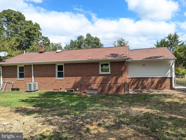 back of house featuring central AC unit and a yard