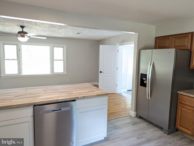 kitchen featuring appliances with stainless steel finishes, light hardwood / wood-style floors, butcher block counters, and ceiling fan