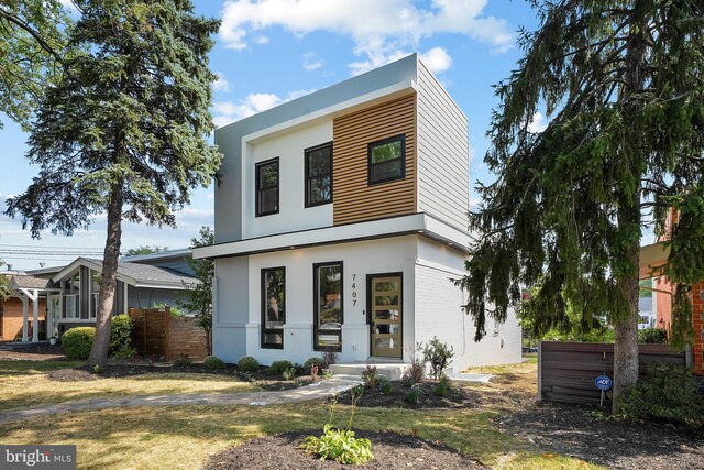 contemporary house with brick siding, fence, and stucco siding