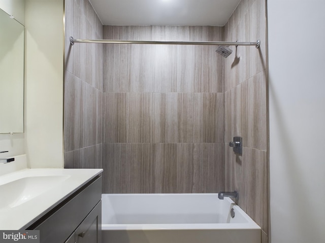 bathroom with tiled shower / bath combo and vanity