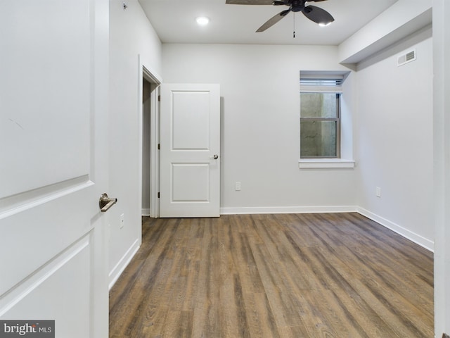 spare room featuring ceiling fan and dark hardwood / wood-style flooring