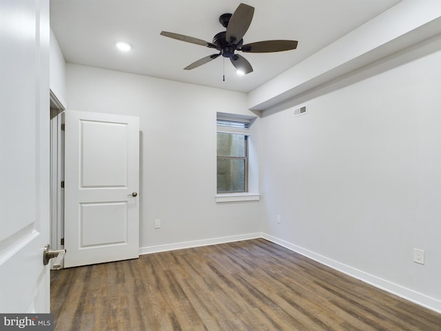 empty room with ceiling fan and dark hardwood / wood-style floors