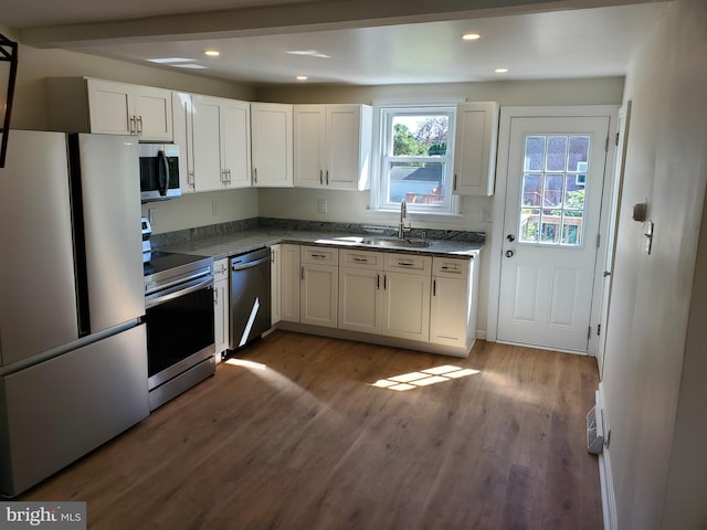 kitchen with white cabinetry, stainless steel appliances, dark hardwood / wood-style floors, and sink