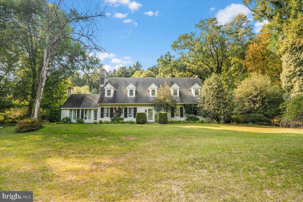 new england style home featuring a front yard