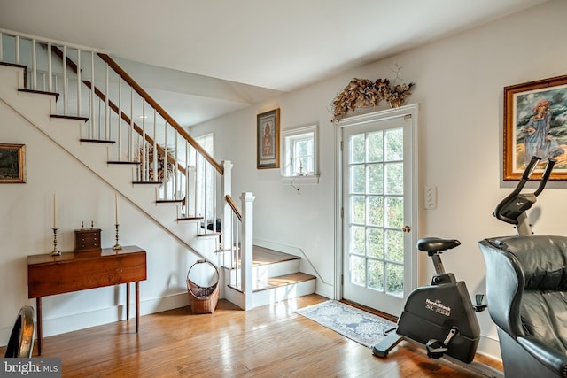 foyer featuring stairs, baseboards, and wood finished floors