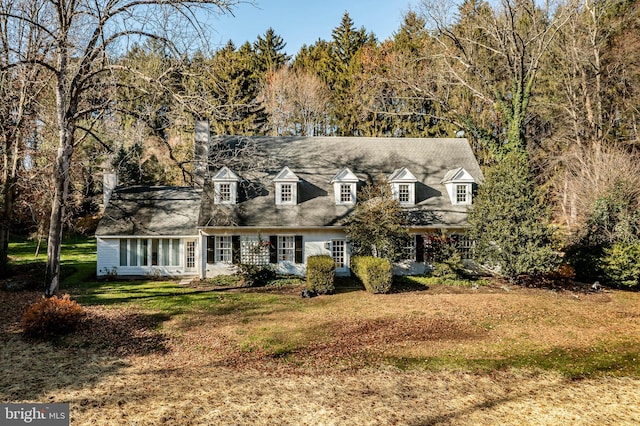 cape cod house with a front lawn