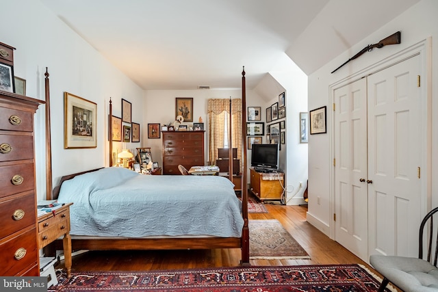 bedroom featuring a closet, visible vents, and wood finished floors