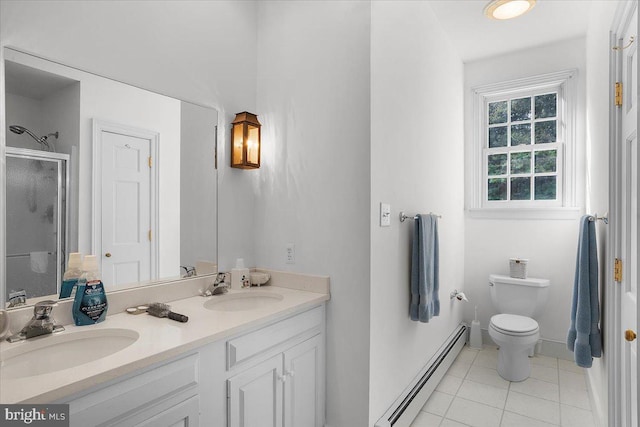 bathroom featuring a baseboard heating unit, double vanity, a sink, and tile patterned floors