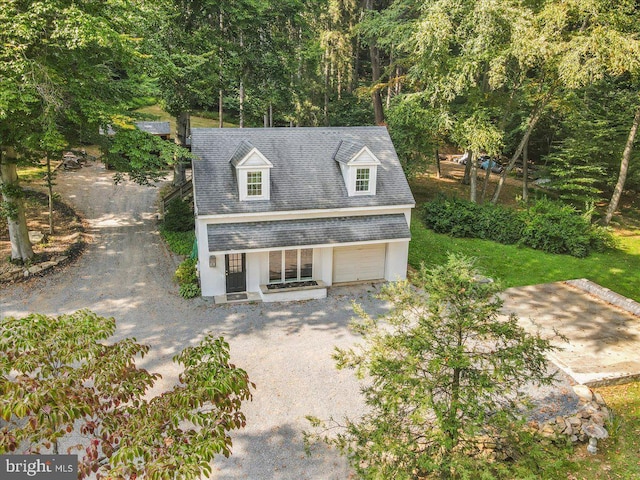 view of front of house with a garage, driveway, and a shingled roof