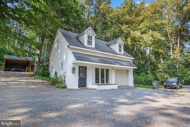 view of front of property with driveway, roof with shingles, and stucco siding