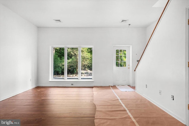 spare room with light wood finished floors and visible vents