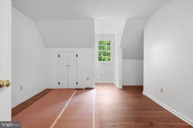 additional living space featuring baseboards, vaulted ceiling, and hardwood / wood-style floors