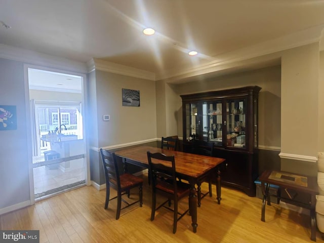 dining room with ornamental molding and light wood-type flooring