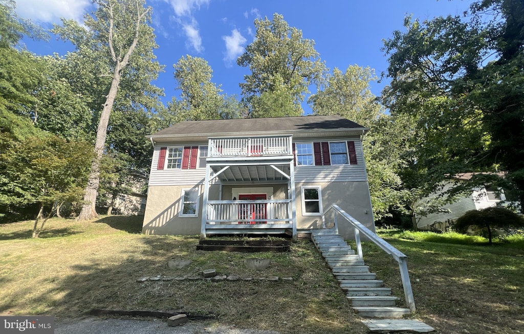 view of front of home featuring a balcony and a front yard