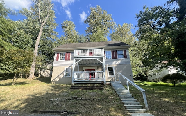 view of front of home with a front lawn and a balcony