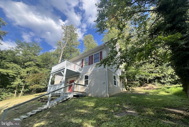 view of front of home featuring a front lawn and a balcony