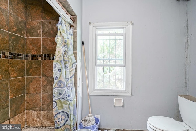 bathroom with toilet and curtained shower