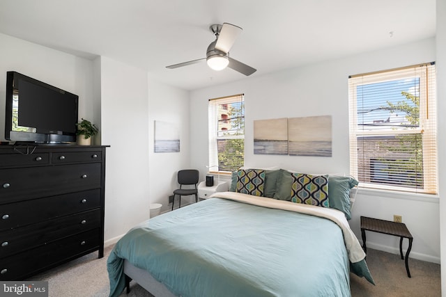 carpeted bedroom with ceiling fan and multiple windows