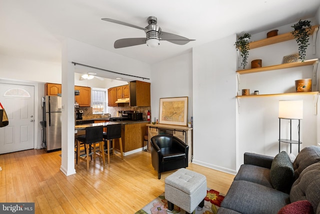 living room featuring light hardwood / wood-style floors, sink, and ceiling fan