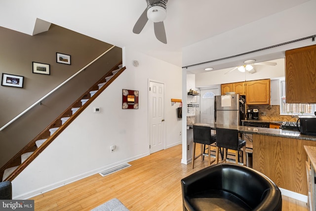 kitchen featuring light wood-type flooring, stainless steel refrigerator, and ceiling fan