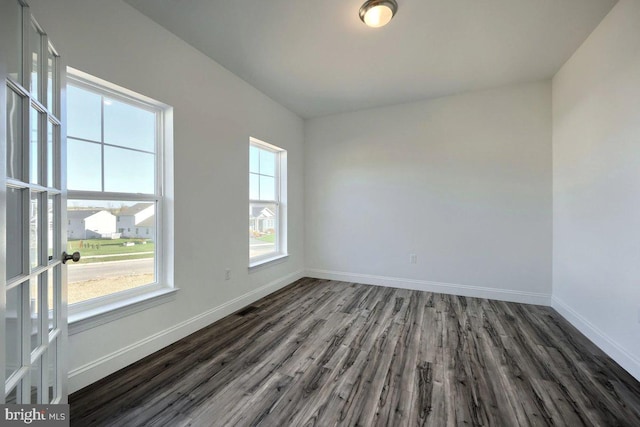 unfurnished room with dark hardwood / wood-style flooring