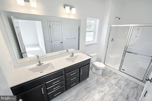 bathroom featuring vanity, toilet, and a shower with shower door