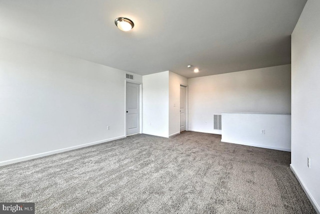 unfurnished room with dark carpet