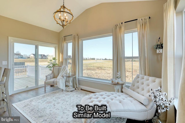 sitting room featuring a chandelier, vaulted ceiling, and wood-type flooring