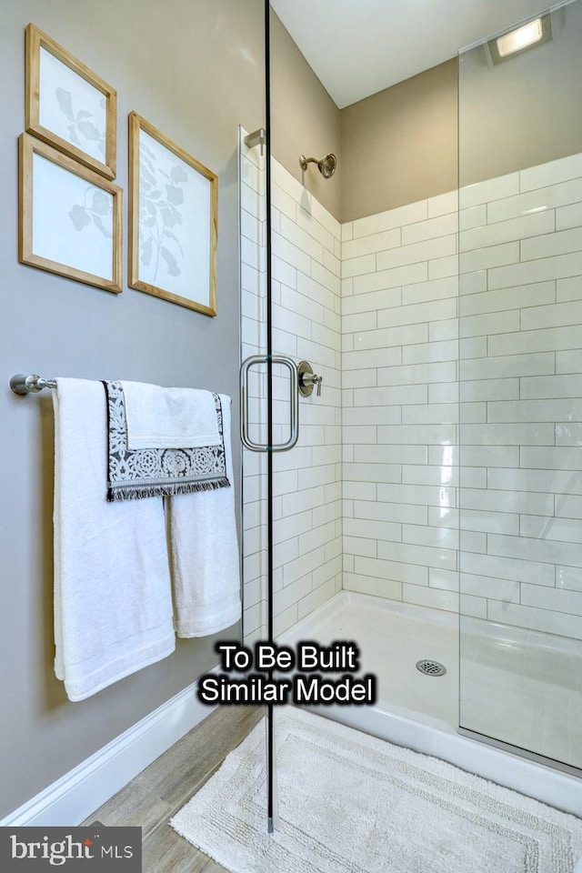 bathroom with hardwood / wood-style floors and a shower with shower door