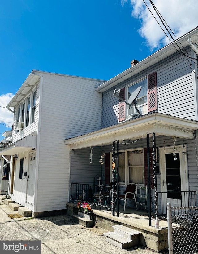 view of front facade with a porch and a chimney