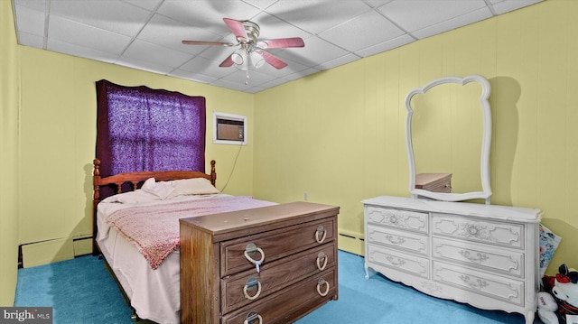 carpeted bedroom featuring a baseboard heating unit, ceiling fan, and a paneled ceiling